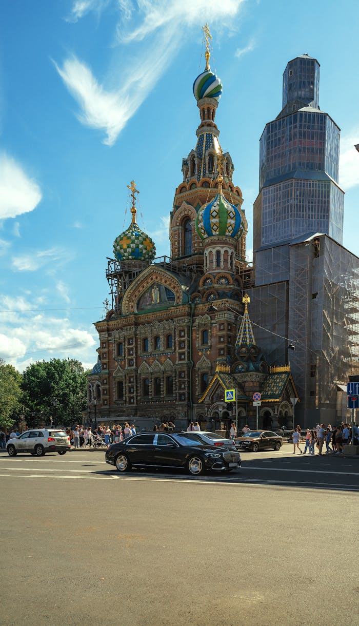 View of the Church of the Savior on Spilled Blood in Saint Petersburg on a sunny day with people and cars around.